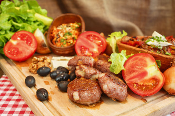 Meat burgers and vegetable.Stew in pot on wooden plank