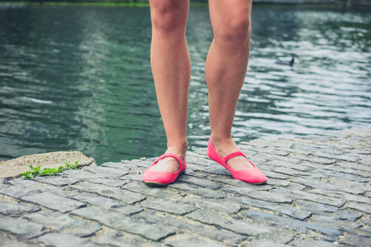Legs and feet of young woman by canal