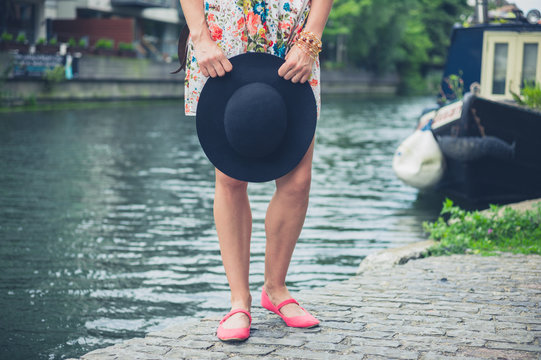 Young woman with hat by canal