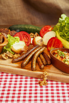 Stew in pot on wooden plank. Various vegetable, meat and sausages. Traditional cuisine.