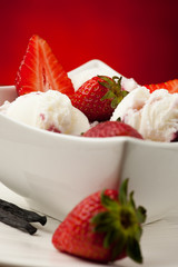 Strawberry icecream in a white bowl  with strawberries