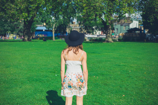 Young woman with hat standing in park