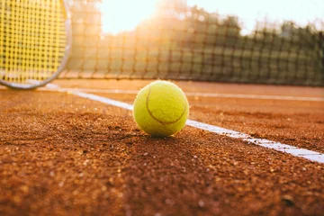 Fotobehang Tennisracket en bal op een gravelbaan © yossarian6