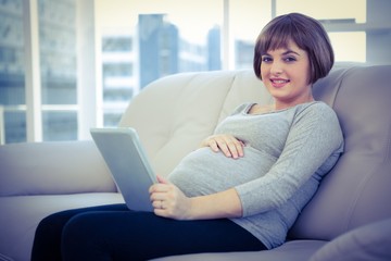 Obraz premium Portrait of pregnant woman using digital tablet 