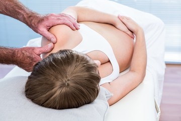 Obraz na płótnie Canvas Close-up of male masseur massaging pregnant woman