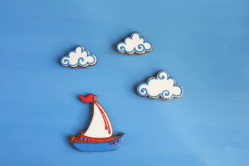 Zelfklevend Fotobehang Homemade gingerbread cookies in the shape of boats, clouds  © fieryphoenix