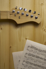 Guitar and Sheet music on wood.