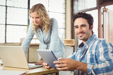 Portrait of smiling man with woman working in office