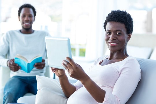Portrait of pregnant woman holding digital tablet - Powered by Adobe