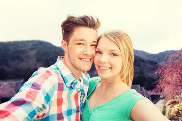 Fototapeta premium smiling couple taking selfie over asian landscape