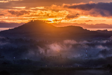 Fototapeta premium sunrise behind mountain and fog