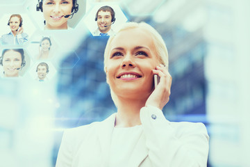 smiling businesswoman with smartphone outdoors