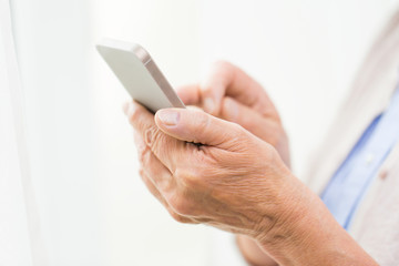 close up of senior woman with smartphone texting