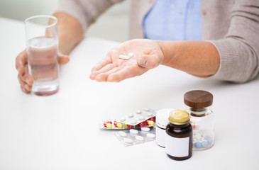 close up of senior woman with pills and water 