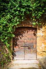 Fototapeta na wymiar Old destroyed door to the Tuscan home