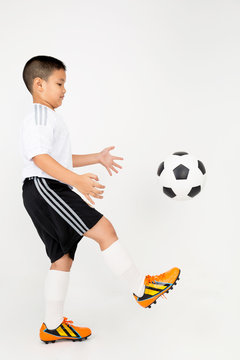 Portrait of Little asian boy with cocker ball in sport uniform