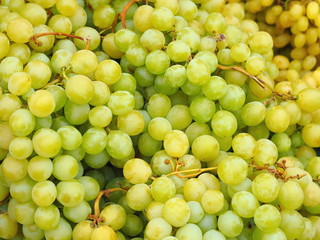 Pile of white wine grapes at market stall.
