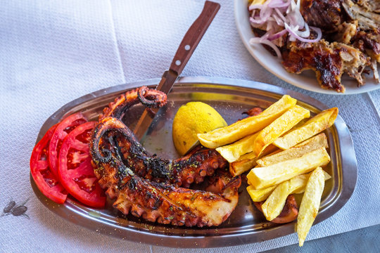 Grilled octopus with fries on the plate