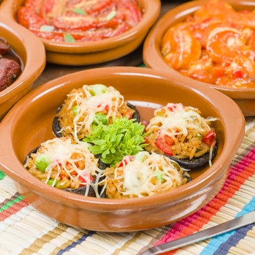 Stuffed Mushrooms - Mushrooms topped with cooked spicy rice and cheese. Surrounded by other tapas dishes.