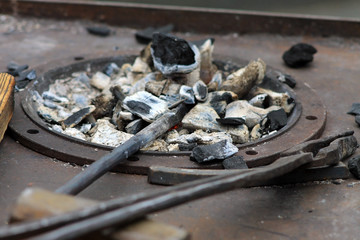 Кузнечный щипцы и уголь