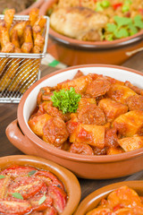 Tapas - Selection of latin dishes. Chorizo al vino, Higados de pollo, Chicken and chorizo, Tomates al ajillo, Arroz con pollo, Camarones enchilhados, Patatas a ala riojana and Stuffed mushrooms.
