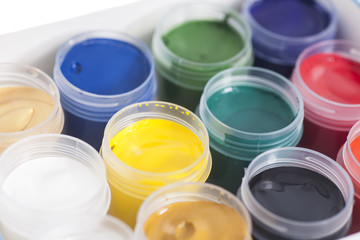 Open colorful cans of gouache paint