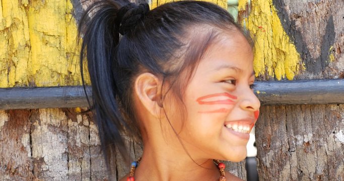Cute native Brazilian girl smiling at an indigenous tribe in the Amazon