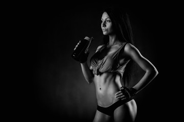 Brutal athletic woman pumping up muscles with dumbbells