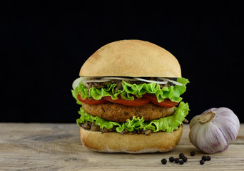 Juicy burger on wooden board with garlic