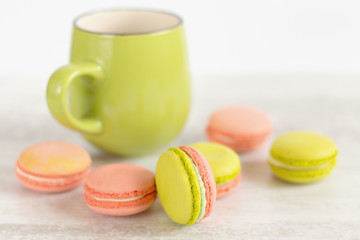Green and pink colorful macaroons with green mug