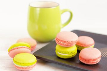Green and pink colorful macaroons with green mug