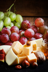 Snack plate for wine: cheese, green and pink grapes, figs, nuts