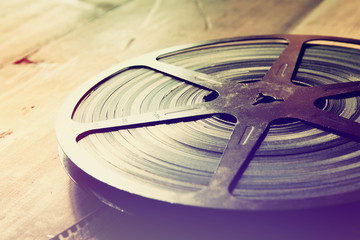 image of old 8 mm movie reel over wooden background. retro style image
