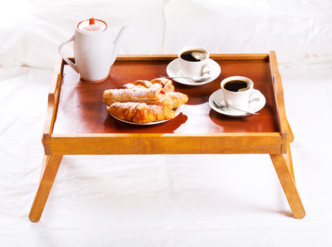 Breakfast in bed. Tray with coffee and pastry