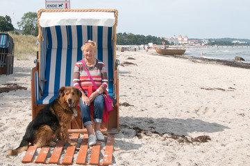 Seniorin mit Hund in Binz am Hundestrand