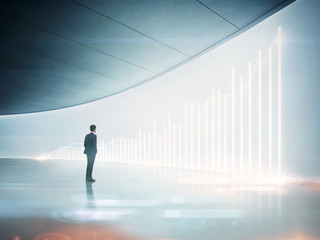 Businessman looking at shining chart on the wall