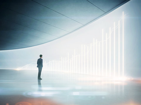 Businessman looking at shining chart on the wall
