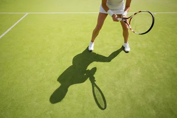 Badkamer foto achterwand Female tennis player on green court grass © Kaspars Grinvalds
