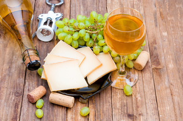 Cheese, grape and wine on wooden background