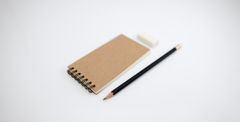 Brown cover notebook with pencil and eraser.