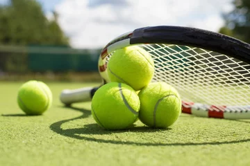 Fotobehang Tennis balls and racket on the grass court © Kaspars Grinvalds