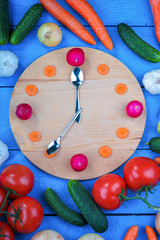 Clock dial made from vegetables among fresh vegetables