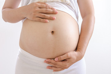 Close up pregnant women touching her belly with hands