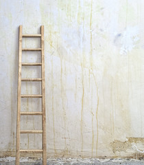 weathered stucco wall with wooden ladder
