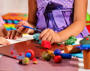 Children hands playing plasticine.