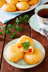 Fried donuts cakes with tomato and cheese, nga wooden table