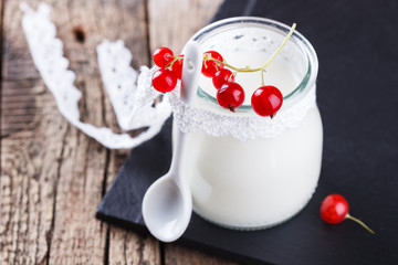 Homemade yoghurt with red currants in a glass jar.selective focus