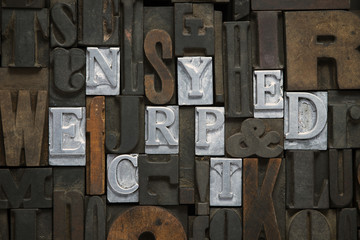 encrypted concept made from metallic letterpress blocks in mixed wooden letters 
