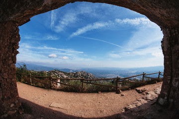 Obraz premium view from a cave on the mountain path , mountains and sky