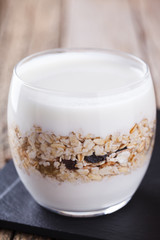 Breakfast with muesli, yogurt in a glass on a wooden background. selective focus